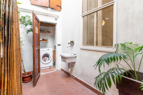 uma casa de banho com um lavatório e uma máquina de lavar roupa em Livorno-Mercato delle Vettovaglie Central Apt! em Livorno