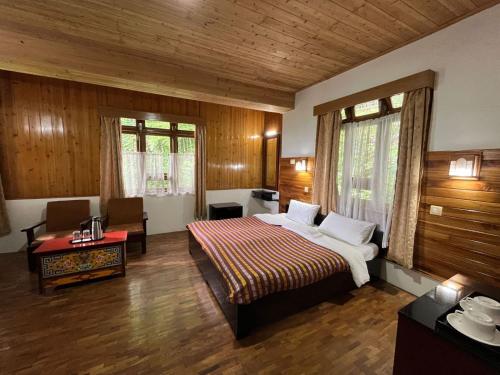 a hotel room with a bed and a desk and a room at Mintokling Guest House in Gangtok