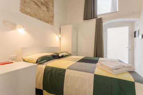a bedroom with a bed with a colorful blanket at La Maddalena Suite & Rooms in Bitonto
