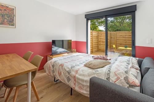 ein Schlafzimmer mit Bett und Tisch und ein Esszimmer in der Unterkunft L'Escale du Voyage à Nantes in Saint-Sébastien-sur-Loire