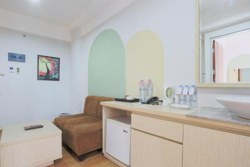 a bathroom with a counter and a sink and a chair at Hotel Gunawangsa Manyar in Surabaya
