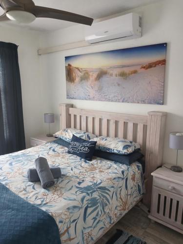 a bedroom with a bed with a painting on the wall at 22 Key Largo in Kingsborough