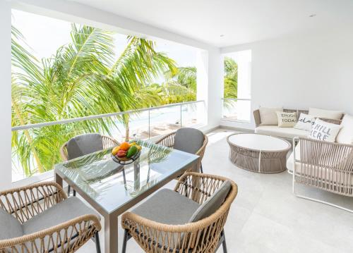een balkon met een tafel en stoelen en een bank bij Aqua Esmeralda Luxury Beach Front Apartment in La Laguna