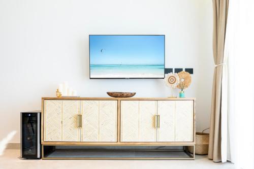 een televisie op een dressoir in een woonkamer bij Aqua Esmeralda Luxury Beach Front Apartment in La Laguna