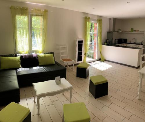 Il comprend un salon avec un canapé et des tables ainsi qu'une cuisine. dans l'établissement La maison au bord du lac, à Château-Guibert