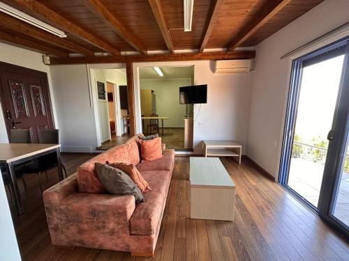 ein Wohnzimmer mit einem Sofa und einem Tisch in der Unterkunft Lefkada Villas - Cheloni Villa Vafkeri in Vavkerí