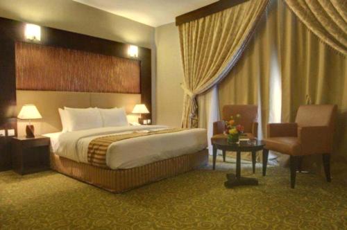 a hotel room with a bed and a chair at Aryana Hotel in Sharjah
