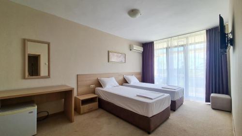 a hotel room with two beds and a window at St. Sofia Beach Hotel in Kiten