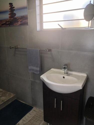 a bathroom with a white sink and a window at 22 Key Largo in Kingsborough