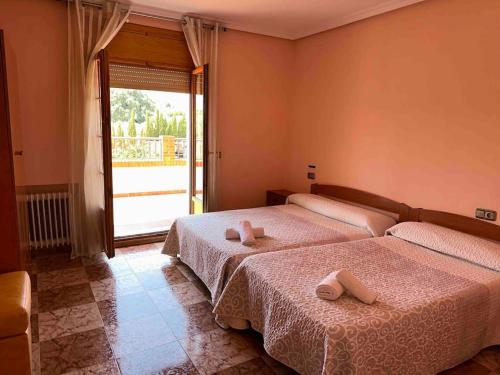 ein Schlafzimmer mit zwei Betten und einem großen Fenster in der Unterkunft Casa Rural Baza in Baza