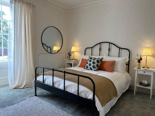 a bedroom with a bed with pillows and a mirror at The Victoria Hotel,Bar,Bistro in Norham