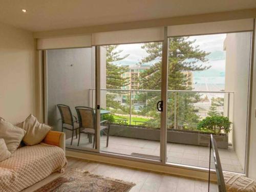 a living room with a couch and a large window at SUNSET GETAWAY GLENELG in Glenelg