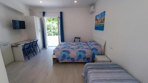 a bedroom with a bed and a desk and a kitchen at Passariello in Ischia