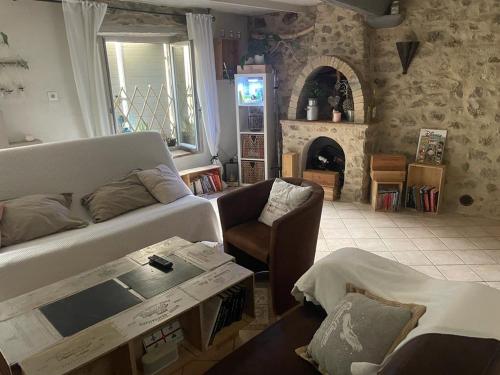 a living room with a couch and a fireplace at Typique maison de village in Peille