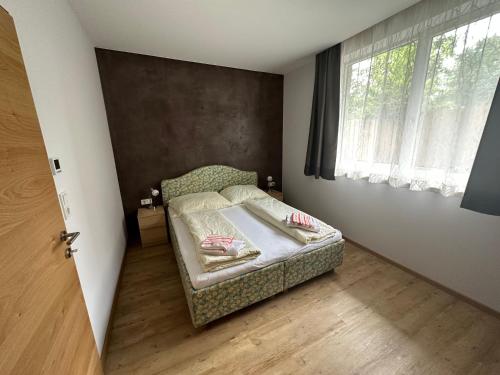 um pequeno quarto com uma cama e uma janela em Top 1 Gartenwohnung em Kitzbühel