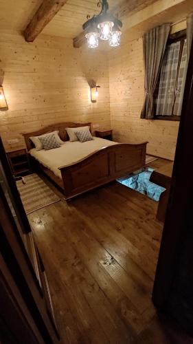 a bedroom with a large bed in a wooden room at Casa de Lemn Maramures in Mara