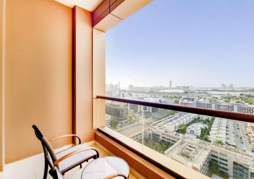 a room with a chair and a large window at Two Seasons Hotel & Apartments in Dubai