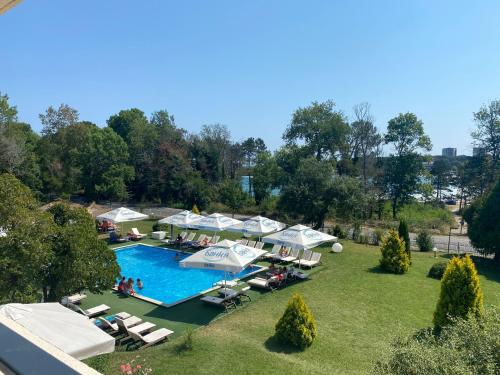 una vista aérea de una piscina con sombrillas y sillas en St. Sofia Beach Hotel en Kiten