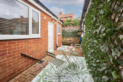 a patio with a table and chairs next to a brick wall at Host & Stay - South Riggs in Bedlington