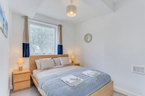 1 dormitorio con 1 cama con 2 toallas en Aryas Apartments London, en Londres
