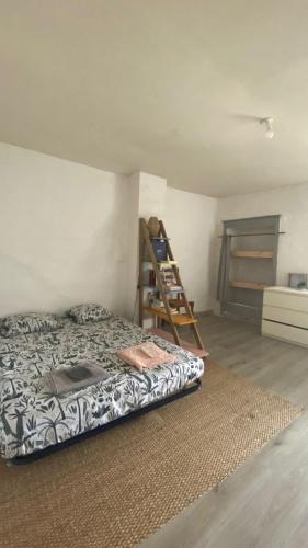 une chambre avec un lit et une échelle dedans dans l'établissement Maison de village proche Cévennes, ancienne bergerie rénovée, à Lèzan