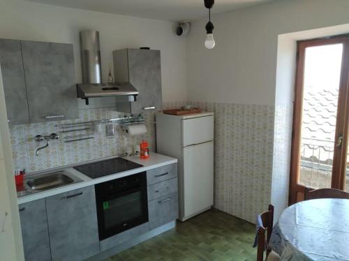 uma cozinha com um lavatório e um fogão forno superior em Casetta con camino per pellegrini e camminatori em Cantalice
