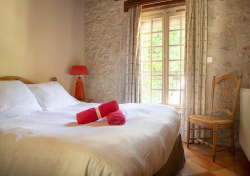 a bedroom with a bed with red towels on it at Les Dépendances de Chapeau Cornu in Vignieu