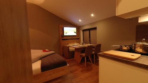 a room with a bed and a kitchen with a table at Haus Alpenglühen in Ehrwald