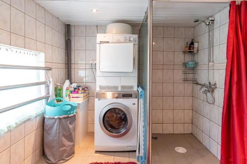 a washer and dryer in a small bathroom at Fantastic 170m2 Villa with a big garden in Pärnu