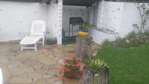 a patio with a white chair and a grill at App ensoleillé Guéthary classé 2 * avec terrasse et jardin privatifs in Guéthary