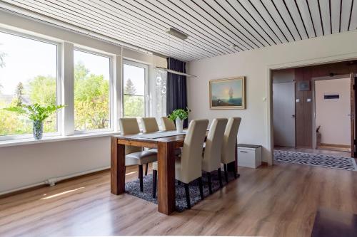 a dining room with a table and chairs and windows at Fantastic 170m2 Villa with a big garden in Pärnu