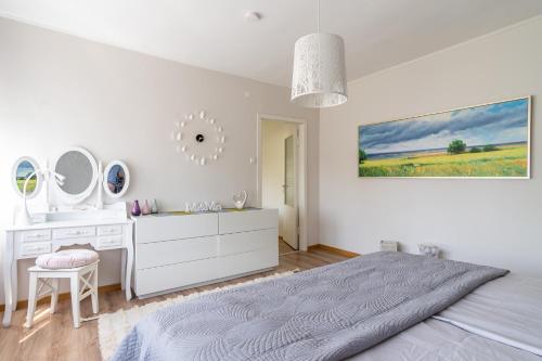 a white bedroom with a bed and a sink and mirror at Fantastic 170m2 Villa with a big garden in Pärnu