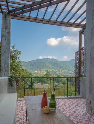 a table with two vases on a balcony with a view at Proud Phu Fah Maerim Resort in Mae Rim
