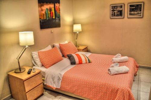 a bedroom with a bed with orange sheets and pillows at Iro Suites in Andros