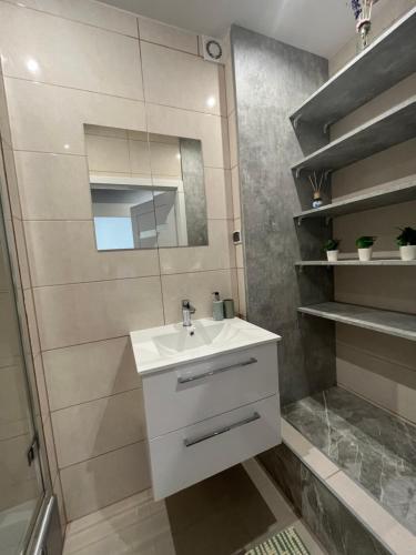a bathroom with a white sink and a shower at Manufaktura Rooms in Łódź