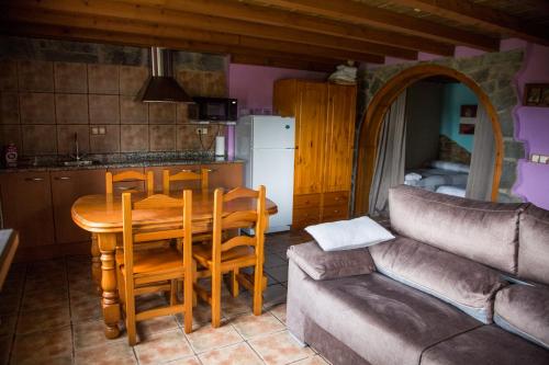 a kitchen and dining room with a table and a couch at Apartamentos Els Ocells in Camprodon