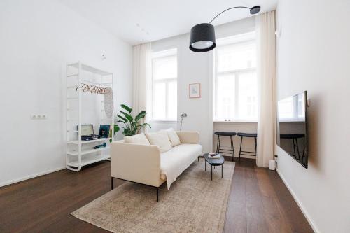 a living room with a white couch and a table at Design Apartment Spittelberg - 7th district - contactless checkin in Vienna