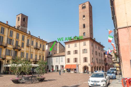 a city street with buildings with two towers at Palazzo Ciravegna in Alba