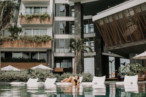 a woman sitting in a pool at a hotel at Bellerive Hoi An Resort and Spa in Hoi An