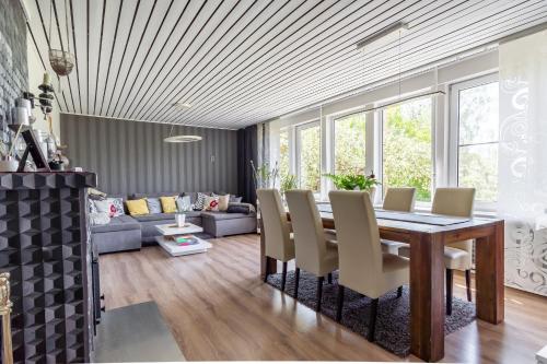 a dining room with a table and chairs and a couch at Fantastic 170m2 Villa with a big garden in Pärnu