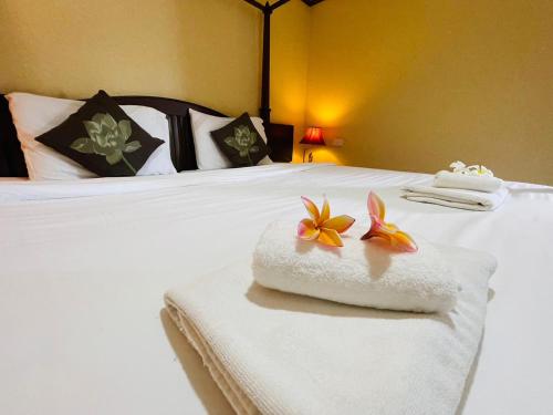a hotel room with a bed with towels on it at Na Thapae Chiangmai Hotel in Chiang Mai