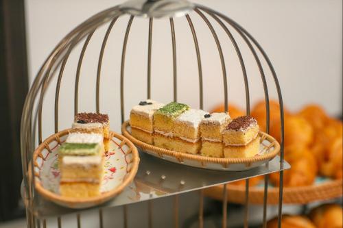 a metal cage with cakes and pastries in it at Media Central Hotel & Spa in Hanoi