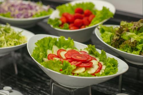 a group of bowls of salad with tomatoes and lettuce at Media Central Hotel & Spa in Hanoi