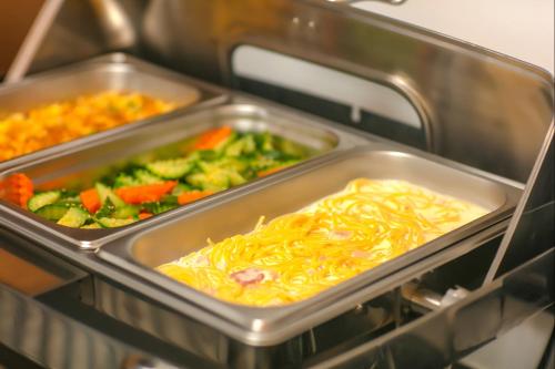 a tray of food in an oven with vegetables at Media Central Hotel & Spa in Hanoi