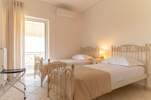 two beds in a room with a window at Villa Katrin 2 in Pylos