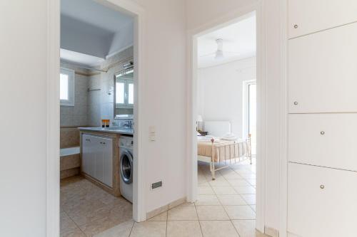 a white kitchen with a washing machine in a room at Villa Katrin 2 in Pylos