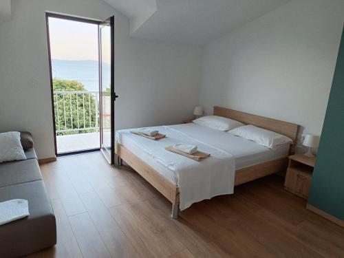 een slaapkamer met een bed en een groot raam bij Apartments Boljat in Trogir