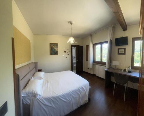 a bedroom with a white bed and a desk at La Capannina in Roccaraso