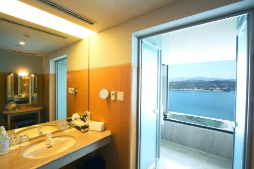 a bathroom with a sink and a shower with a view at Grand Prince Hotel Hiroshima in Hiroshima