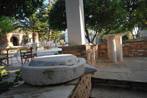a stone bench sitting next to a brick wall at Romano garden house - land tales in Agios Romanos